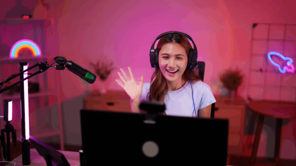 Female creator livestreaming with headphones and mic setup.