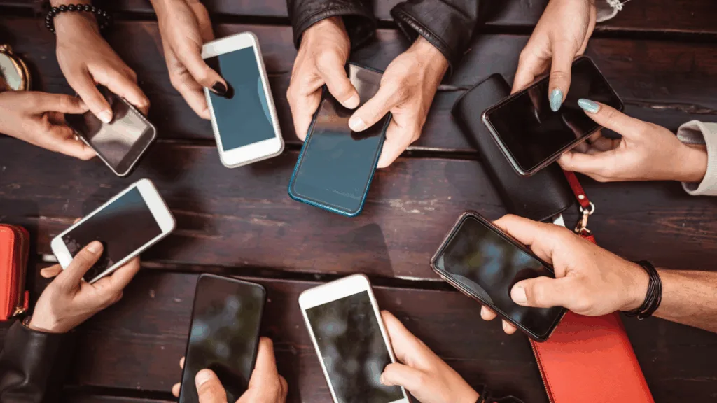 Group of creators using phones to track and compare engagement rates.