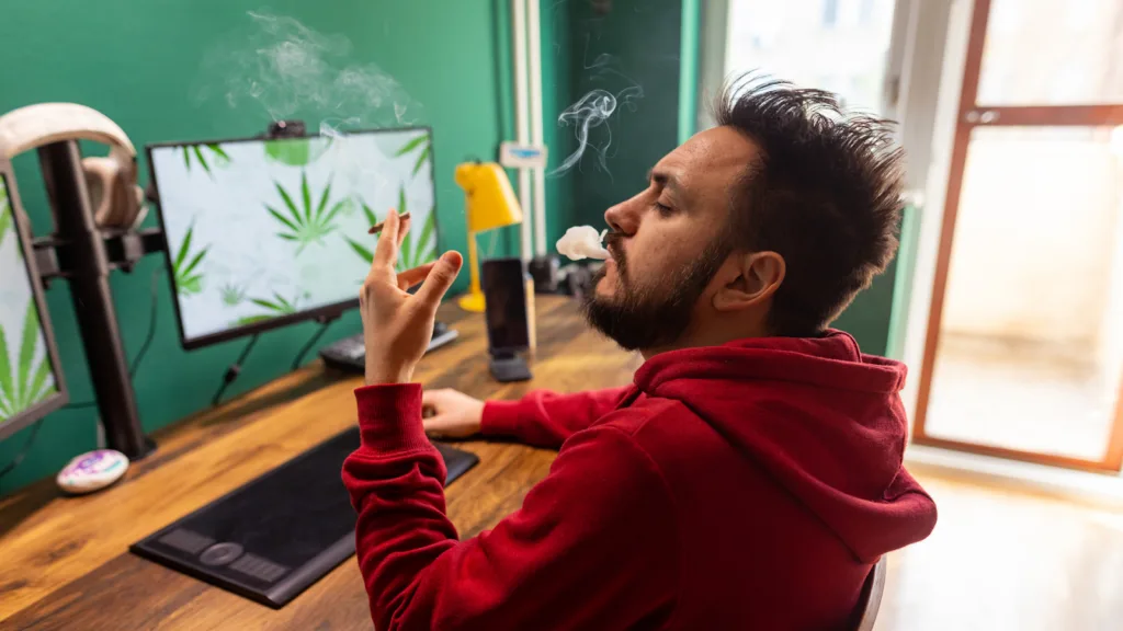 Cannabis influencer creating content at a home setup while smoking