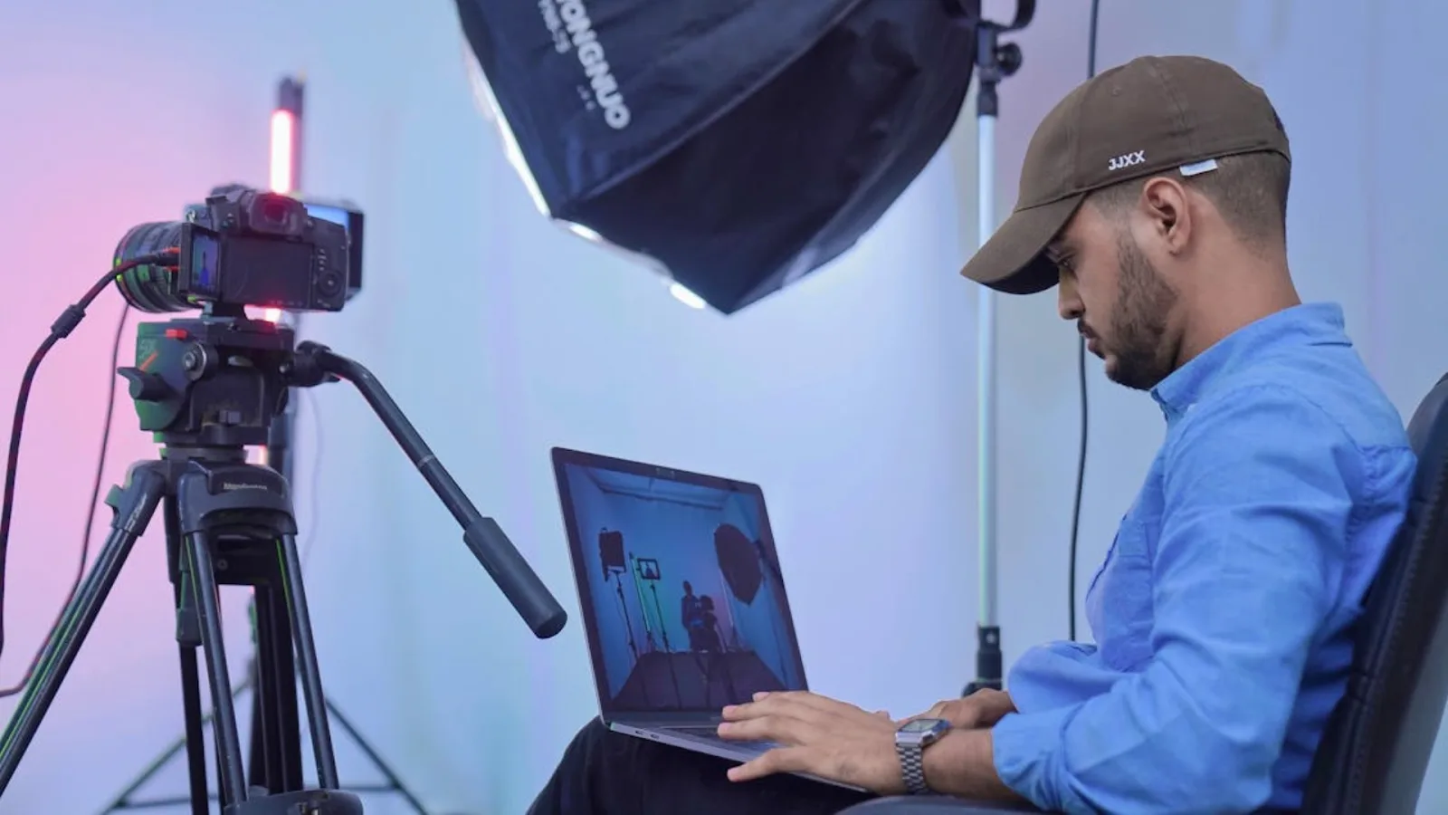 Content creator editing video on a laptop in a studio setup