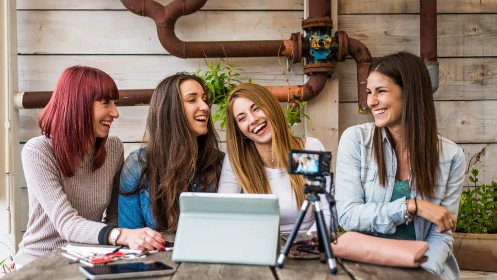 TikTok affiliate program creators filming content as a group using a camera and tablet