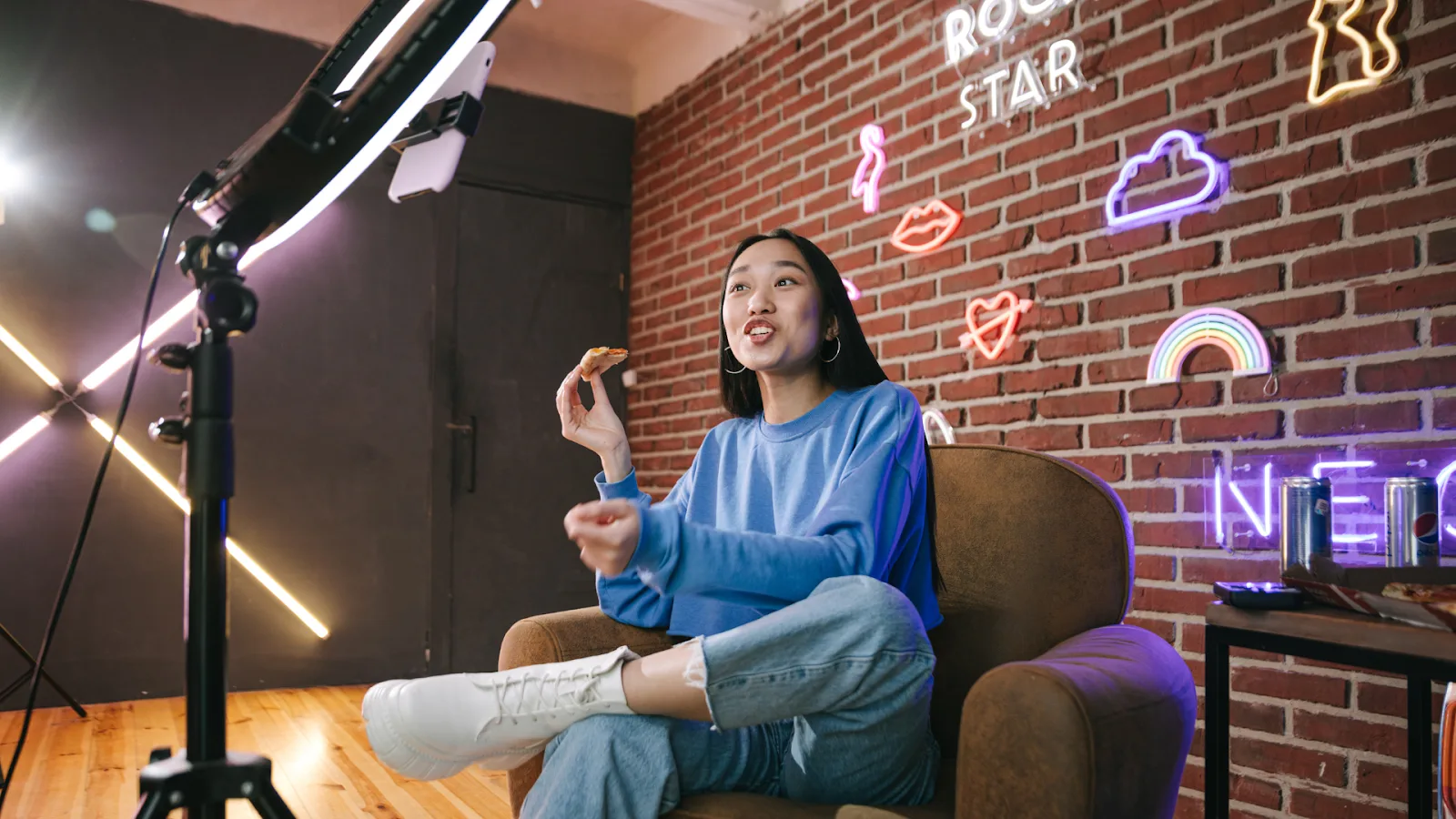 YouTube creator filming in a neon-lit studio.