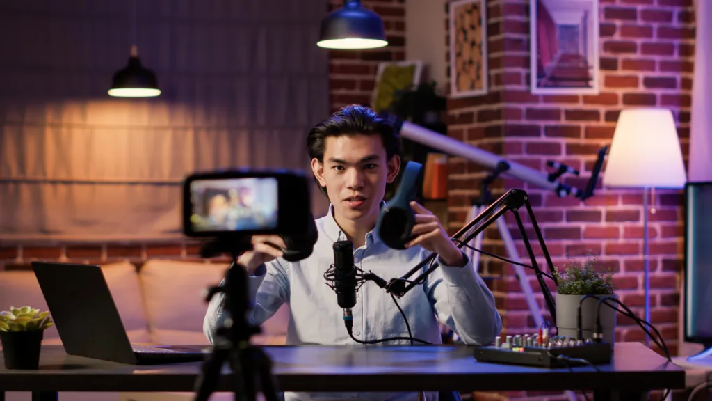 Male content creator filming a review video in a home studio